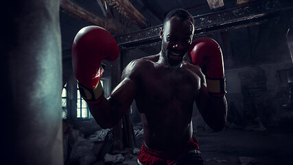 Image showing Hand of boxer over black background. Strength, attack and motion concept