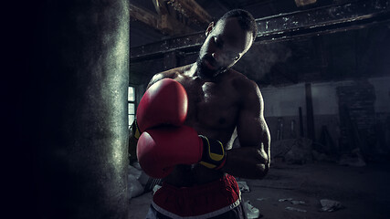 Image showing Hand of boxer over black background. Strength, attack and motion concept