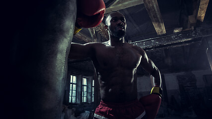 Image showing Hand of boxer over black background. Strength, attack and motion concept