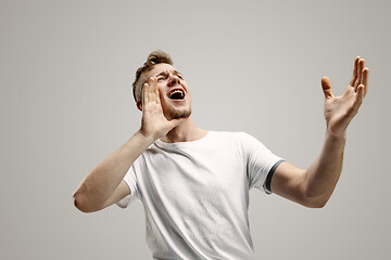 Image showing Isolated on gray young casual man shouting at studio