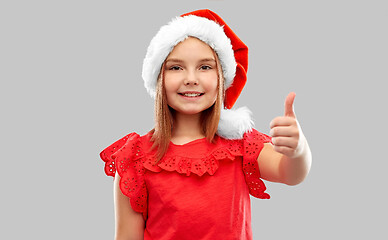 Image showing smiling girl in snata helper hat showing thumbs up