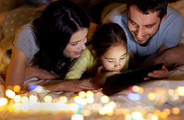 Image showing family with tablet pc in bed at night at home