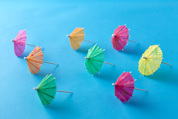 Image showing cocktail umbrellas on blue background