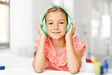 Image showing girl in headphones listening to music at home