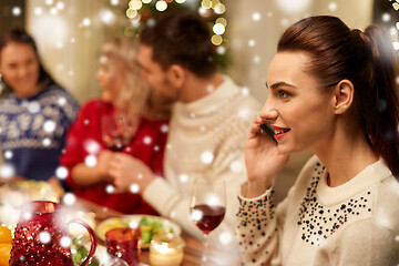 Image showing woman calling on smartphone at christmas dinner
