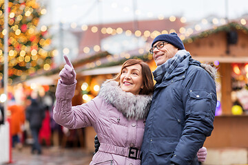 Image showing happy senior couple hugging at christmas market