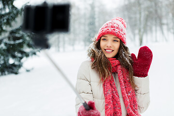 Image showing young woman taking selfie by monopod in winter