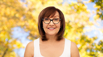 Image showing portrait of senior woman in glasses over autumn
