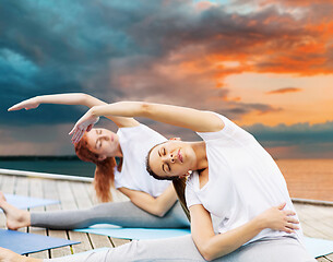 Image showing women making yoga exercises outdoors