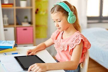 Image showing girl in headphones with tablet computer at home