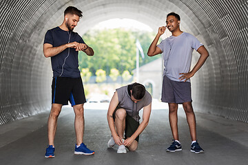 Image showing male friends with earphones training outdoors