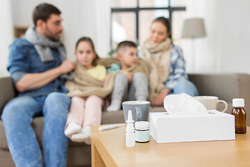 Image showing medicines on table and ill family at home