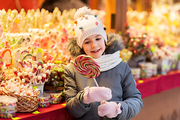 Image showing girl with lollipop at christmas market candy shop