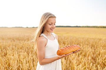 Image showing girl with loaf of white bread on cereal field