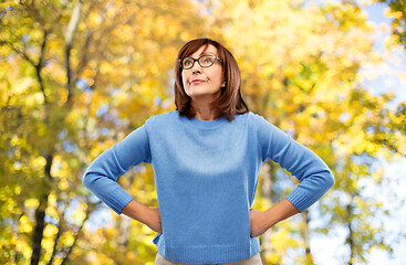 Image showing angry senior woman in glasses over autumn park