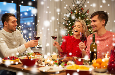 Image showing happy friends drinking red wine at christmas party