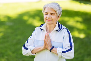 Image showing happy senior woman doing yoga at summer park