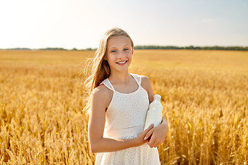 Image showing happy girl with bottle of milk on cereal field