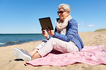 Image showing senior woman with tablet computer on beach