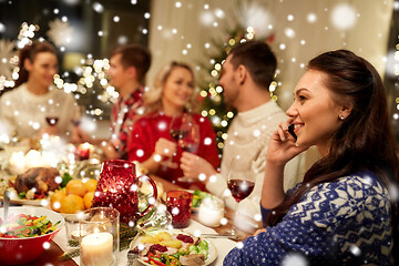 Image showing woman calling on smartphone at christmas dinner