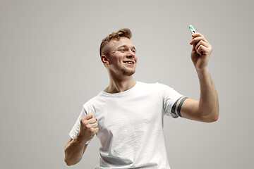 Image showing Happy man looking at pregnancy test at studio