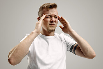 Image showing Man having headache. Isolated over gray background.