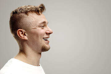 Image showing The happy businessman standing and smiling against gray background.