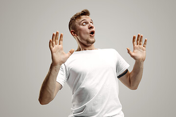 Image showing The young attractive man looking suprised isolated on gray