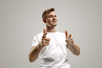 Image showing Stylish handsome young man pointing at studio