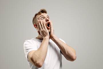 Image showing The young attractive man looking suprised isolated on gray