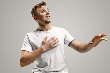 Image showing The young attractive man looking suprised isolated on gray