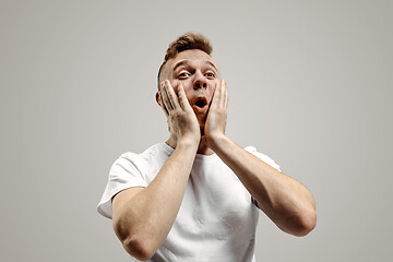 Image showing The young attractive man looking suprised isolated on gray