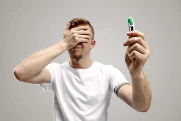 Image showing Upset man looking in pregnancy test. Frustrated model