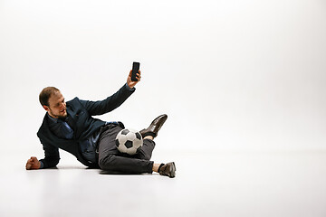 Image showing Businessman with football ball in office