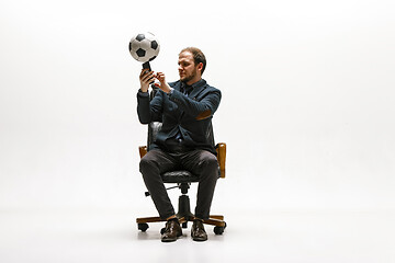 Image showing Businessman with football ball in office