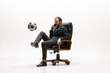 Image showing Businessman with football ball in office