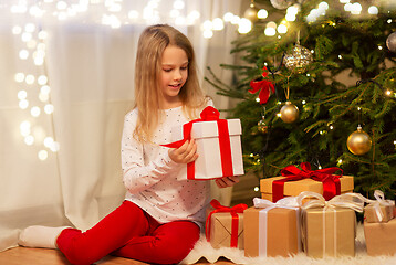 Image showing smiling girl with christmas gift at home