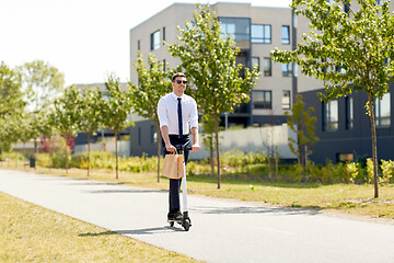 Image showing businessman with lunch in paper bag riding scooter