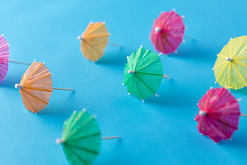 Image showing cocktail umbrellas on blue background