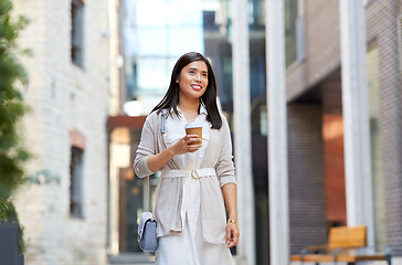 Image showing smiling woman with takeaway coffee cup in city