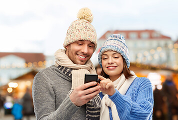 Image showing happy couple with smartphone christmas market