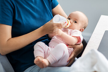 Image showing close up of mother feeding baby with milk formula