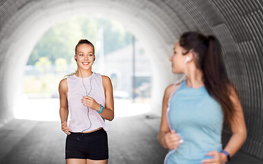 Image showing women or female friends with earphones running