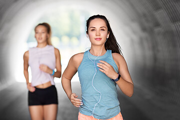 Image showing women or female friends with earphones running