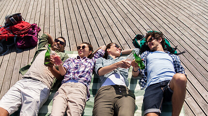 Image showing friends drinking beer and cider on wooden terrace