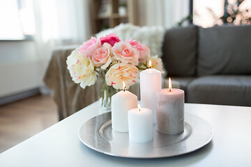 Image showing candles burning on table and flowers at cozy home