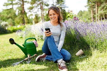 Image showing woman with smartphone and garden tools in summer