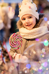 Image showing litle girl with big lollipop at christmas market