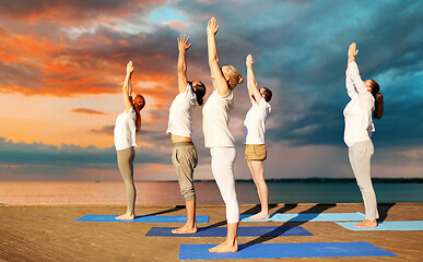 Image showing group of people making yoga exercises outdoors