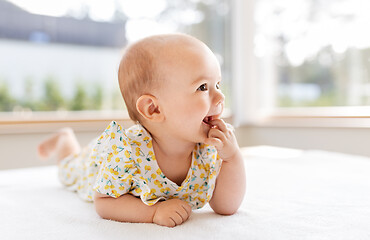 Image showing sweet baby girl lying on white blanket